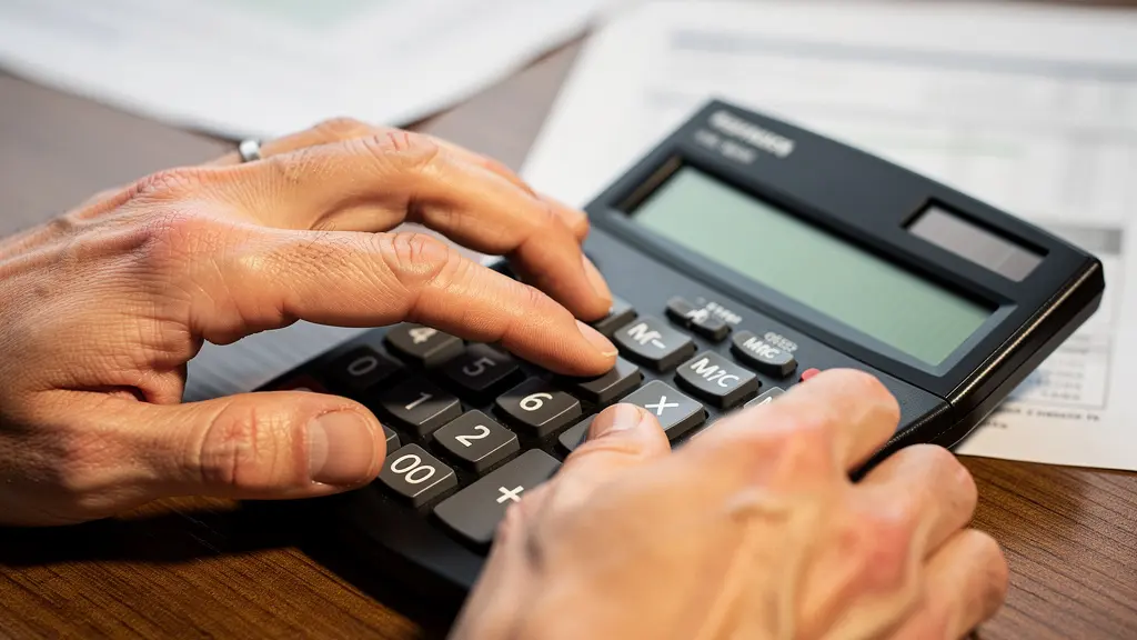 Bureau avec calculatrice et documents financiers flous, mise au point sur les mains
