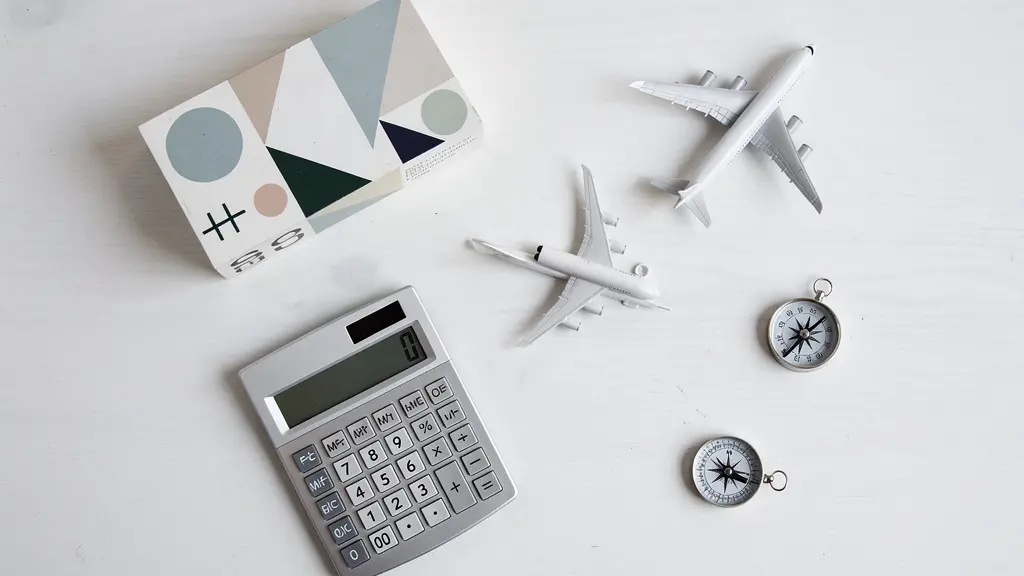 Vue aérienne minimaliste d'un bureau avec calculatrice et calendrier de voyage