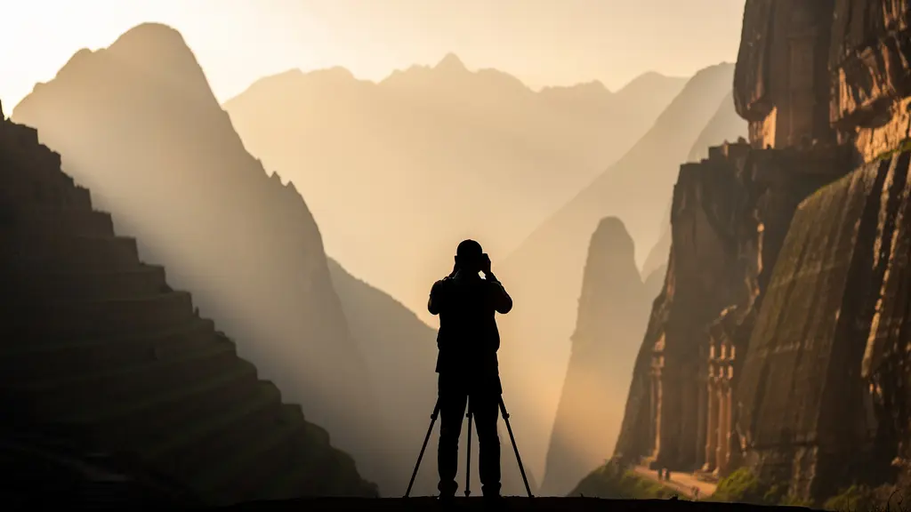 Photographe capturant l'aube sur des ruines antiques entre montagne et désert
